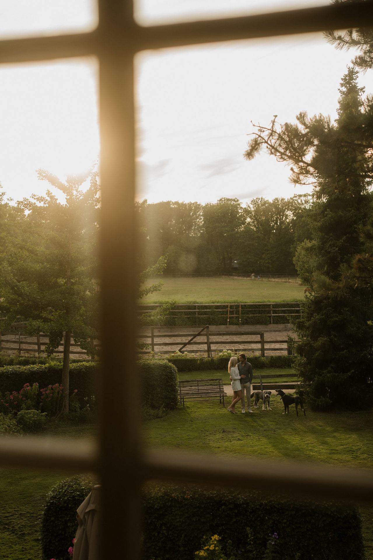 Couple with dogs seen through a window on the estate of De Brennerhoeve